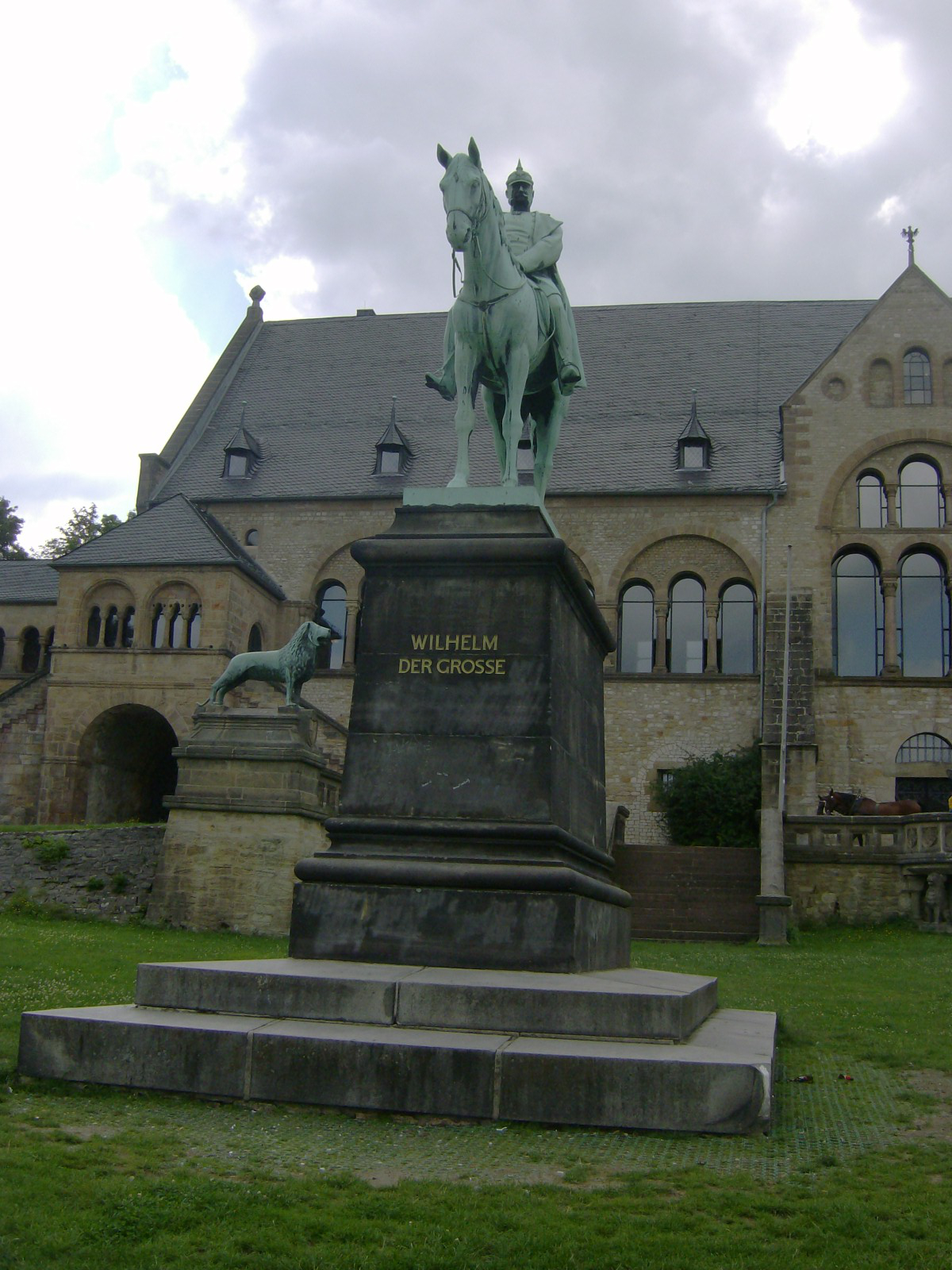 Farbfoto: Das zur Kaiserpfalz gehörende Kaiserhaus und davor das Wilhelm den Ersten darstellende Reiterstandbild und eine Kopie des Braunschweiger Löwen in Goslar im August des Jahres 2011. Fotograf: Ralph Ivert.